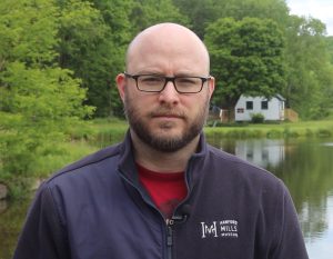 Ryan Jones, HMM Education Coordinator, stands in front of the mill pond.